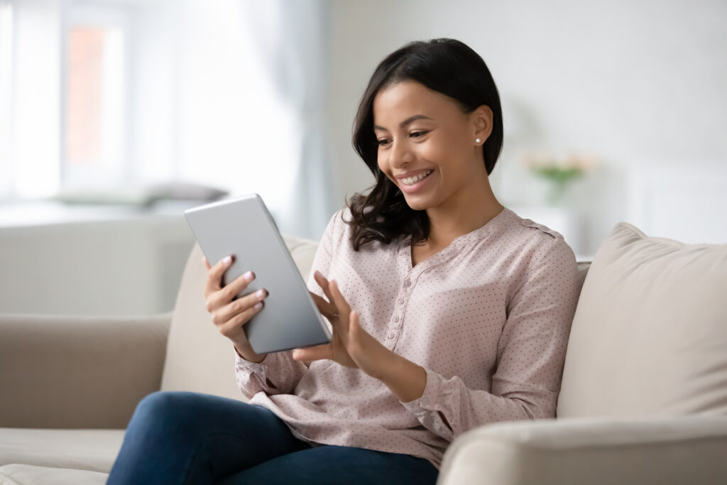 Woman Working At Home on Premier Broadband Internet on Tablet.