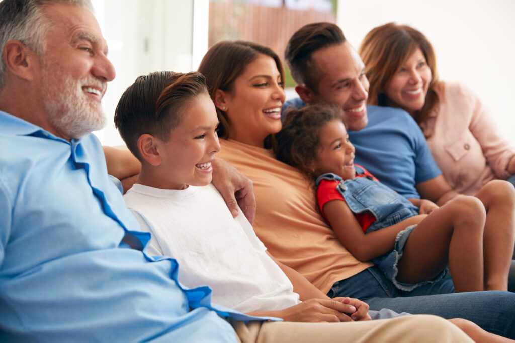 Family Relaxing At Home Sitting On Sofa Watching TV Together using Premier.