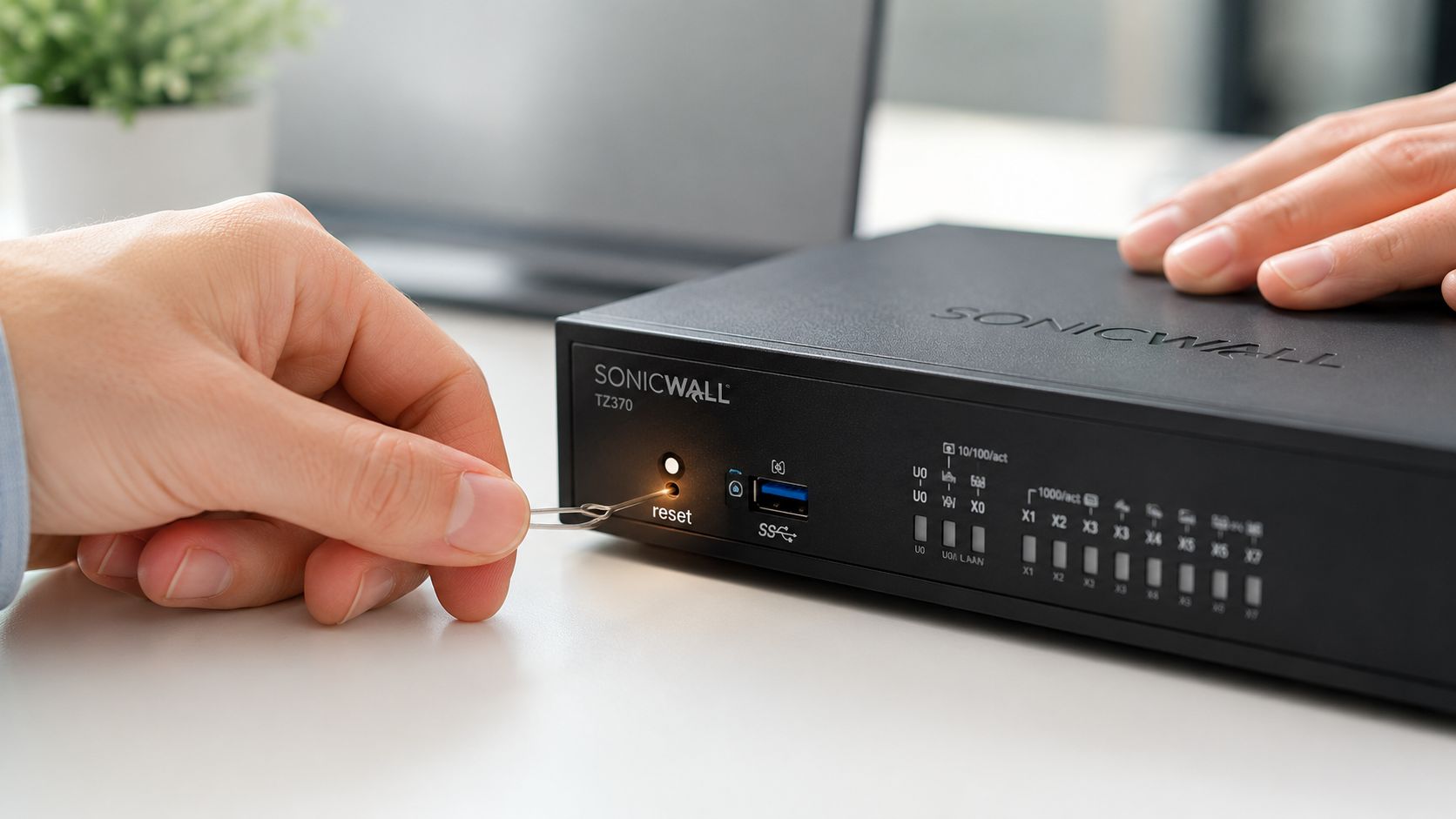 A person uses a paperclip to press the factory reset button on a SonicWall TZ370 network appliance.