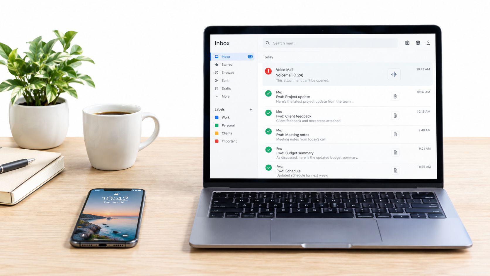 A sleek laptop displays an email inbox showing a notification for a new voicemail on a desk.